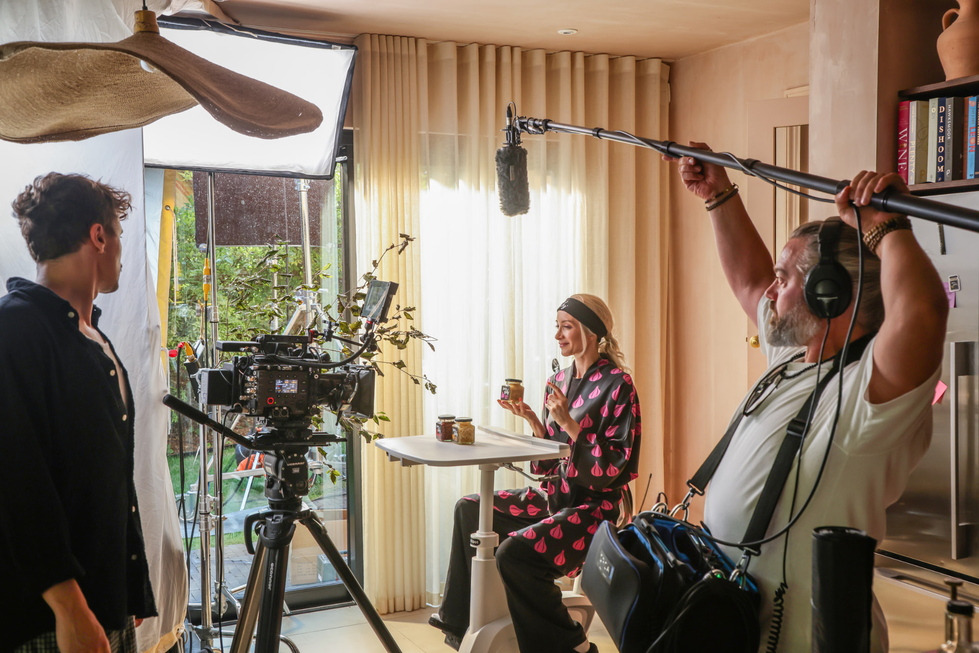 Talent at the desk with boom operator and cinema camera on the Very Lazy shoot