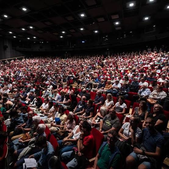 A packed red-seat auditorium during a festival screening